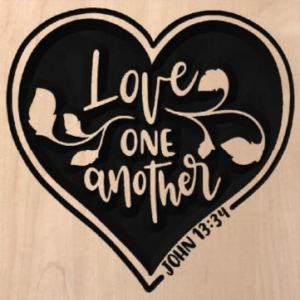 wood sign that says "Love one another" inside a heart, with "John 13:34" written on the side