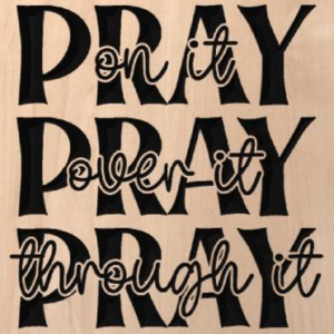 wood sign that says "Pray on it, pray over it, pray through it"