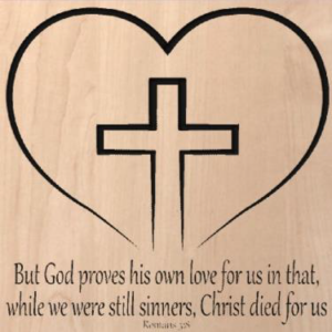 wood sign that says "But God proves his own love for us in that, while we were still sinners, Christ died for us. Romans 3:8" with a cross in a heart above it