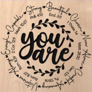 wood sign that says "you are" in the middle with positive words in verses circling it