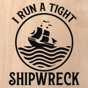 wood sign that says "I run a tight shipwreck" with a ship riding waves in the middle of the words