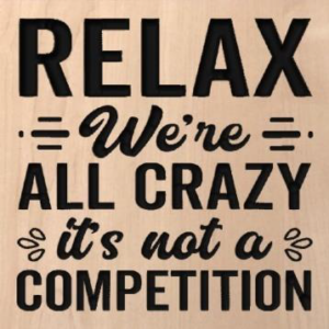 wood sign that says "relax we're all crazy it's not a competition"