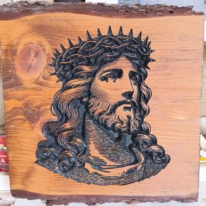 wood sign with Jesus in a crown of thorns carved in black