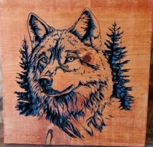 wood sign with realistic wolf head with trees behind it