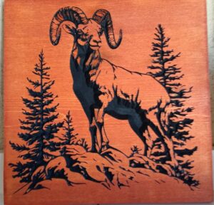 wood sign with realistic elk standing on rocks in front of trees