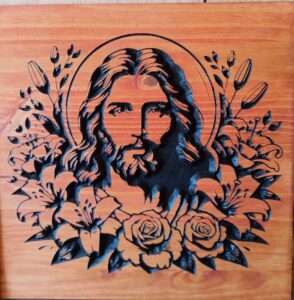 wood sign with Jesus' face surrounded by flowers