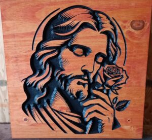 wood sign with Jesus looking down and holding a rose, carved in black