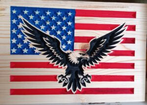 wood sign with american flag in the background and a bald eagle with spread wings in the foreground