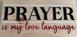 wood sign that says "PRAYER is my love language" in black and red letters, with a white box around prayer.