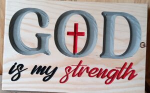 wood sign with text that says "God is my strength" with a cross in the O of "God"